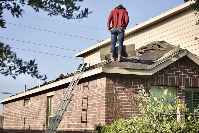 Professional roofer working on a residential roof in Midland Estates
